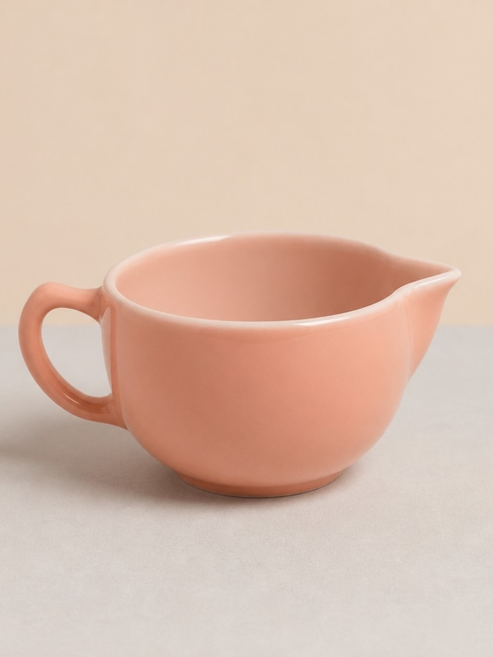 Vintage pink glass creamer by Hazel-Atlas with a C-shaped handle and spout